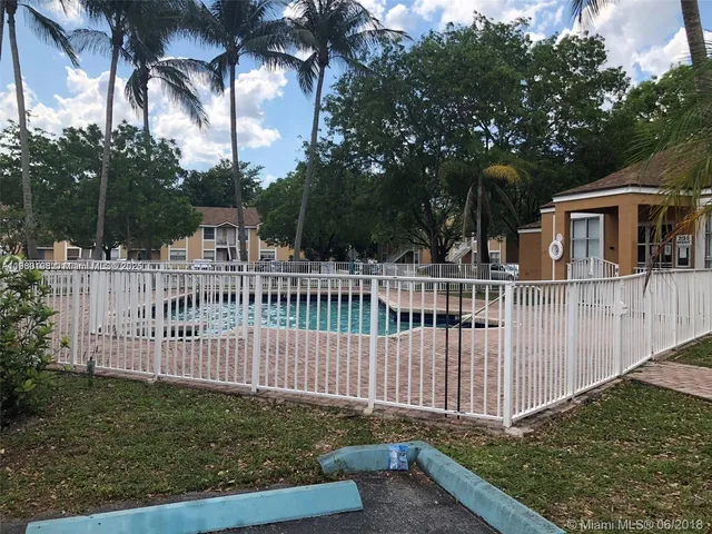 a view of a house with a small yard and wooden fence