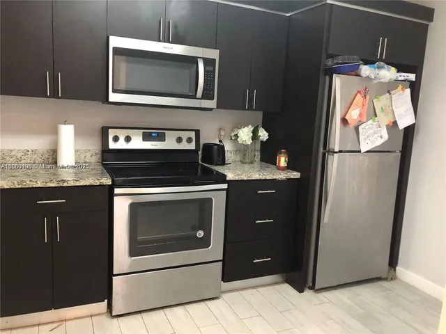 a kitchen with stainless steel appliances granite countertop a refrigerator stove and microwave