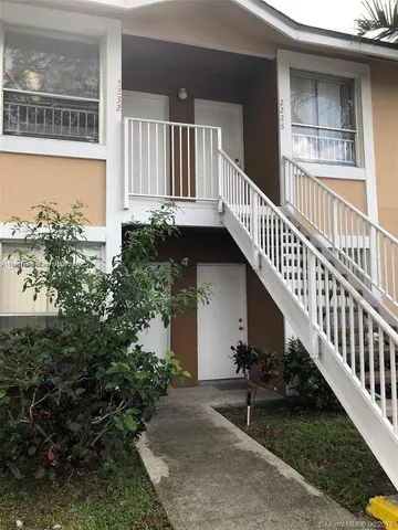 a view of balcony with lots of potted plants and wooden fence