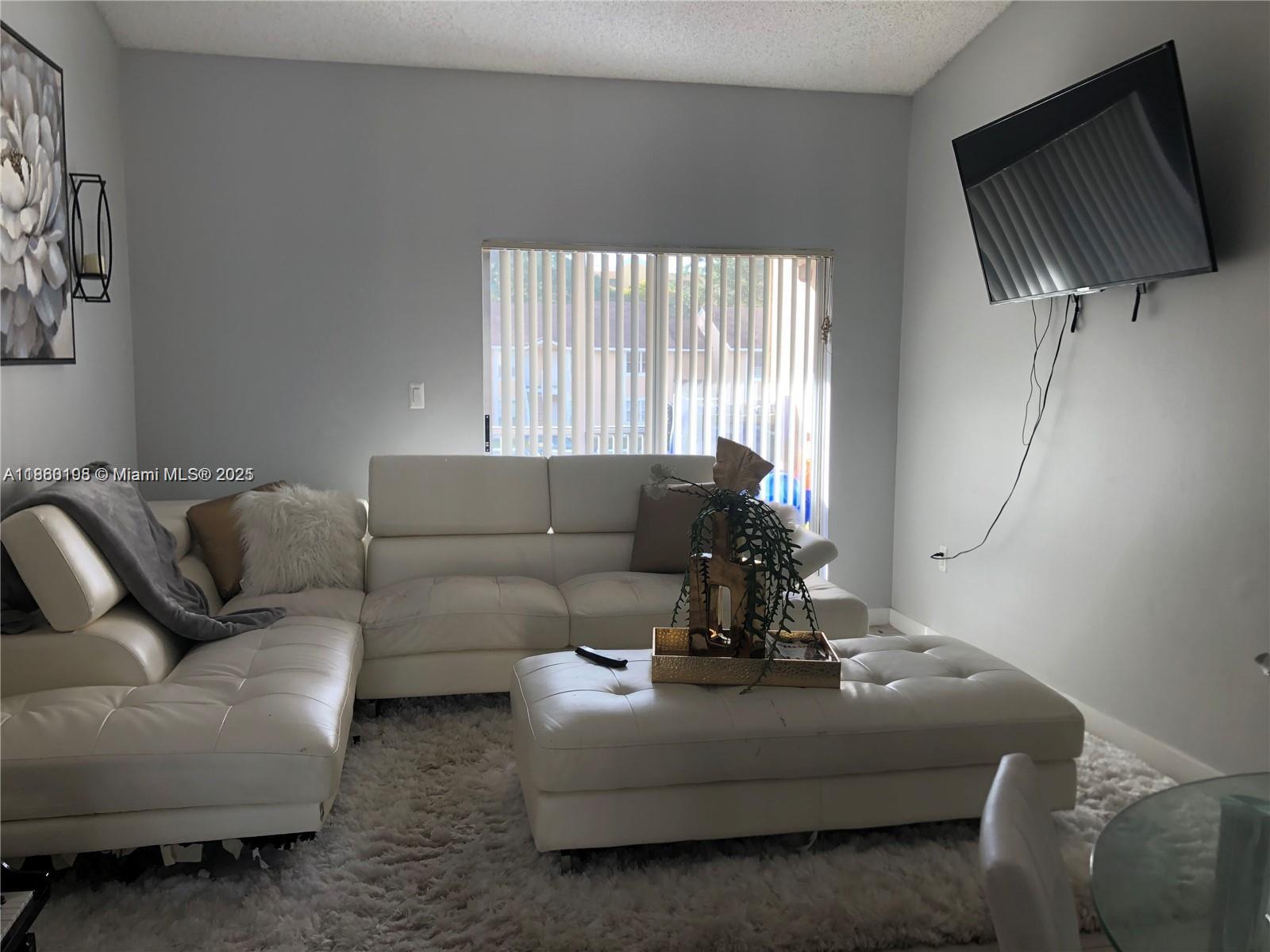 2228 Southwest 80th Terrace, Unit 2228 Miramar, FL 33025 - Photo 5 of 18 a living room with furniture and a flat screen tv