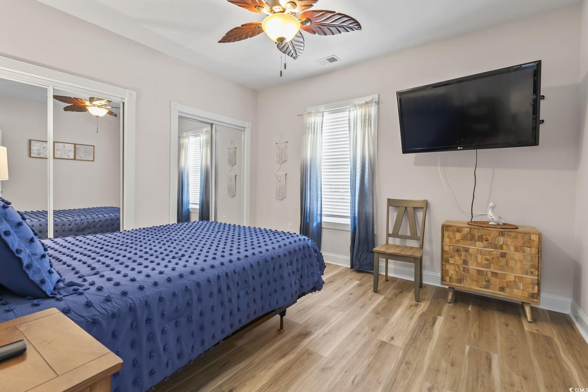 4821 Luster Leaf Circle, Unit 105 Myrtle Beach, SC 29577 - Photo 12 of 40 Bedroom with light wood-style flooring, ceiling fan, and multiple closets