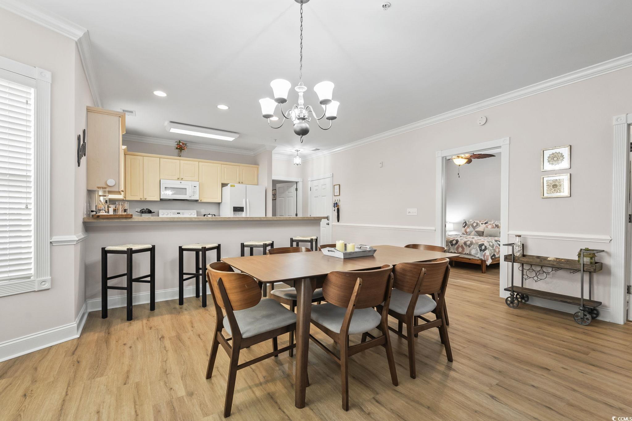 4821 Luster Leaf Circle, Unit 105 Myrtle Beach, SC 29577 - Photo 13 of 40 Dining room with ornamental molding, a chandelier, light wood finished floors, ceiling fan, and recessed lighting