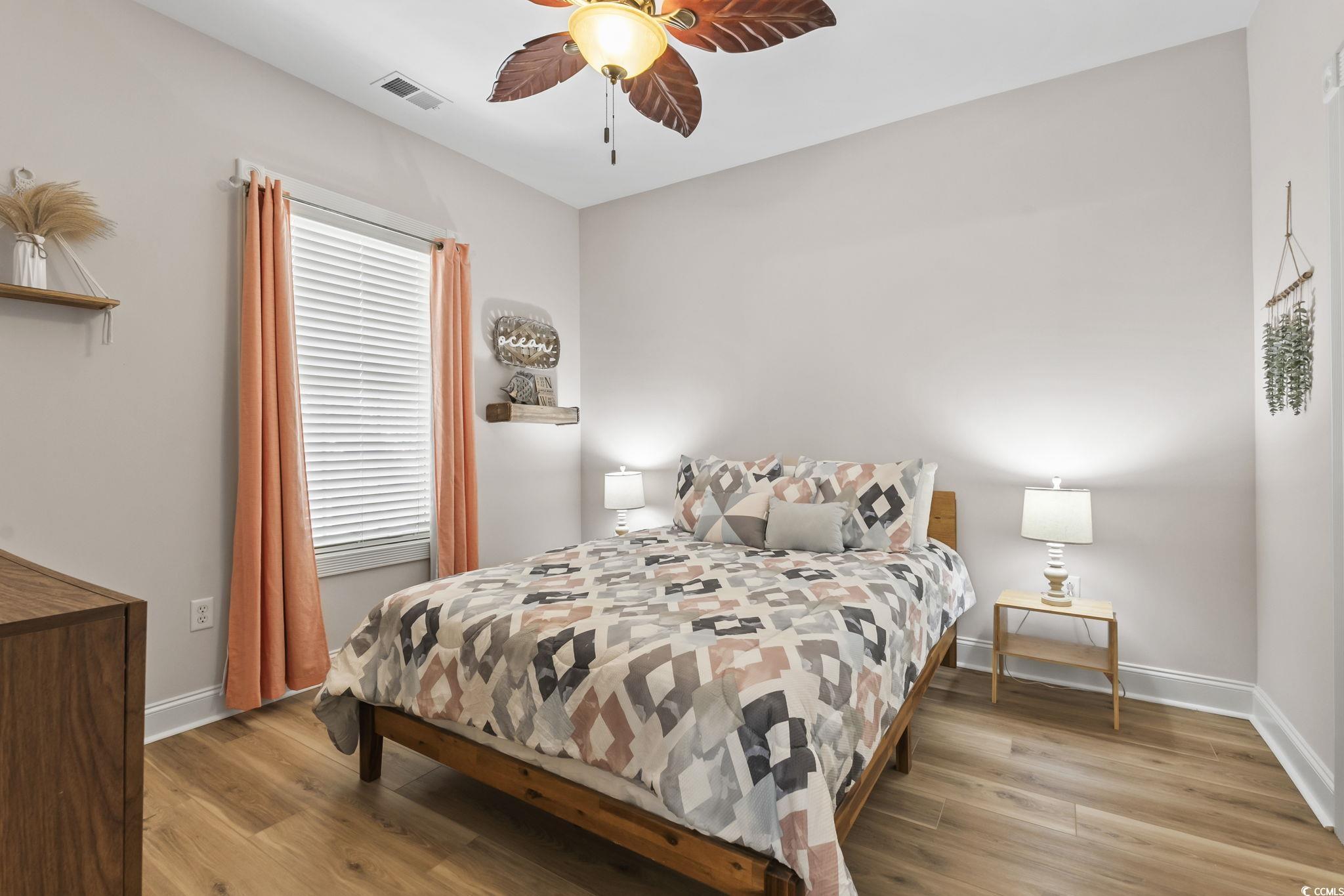 4821 Luster Leaf Circle, Unit 105 Myrtle Beach, SC 29577 - Photo 15 of 40 Bedroom featuring light wood-style floors and a ceiling fan