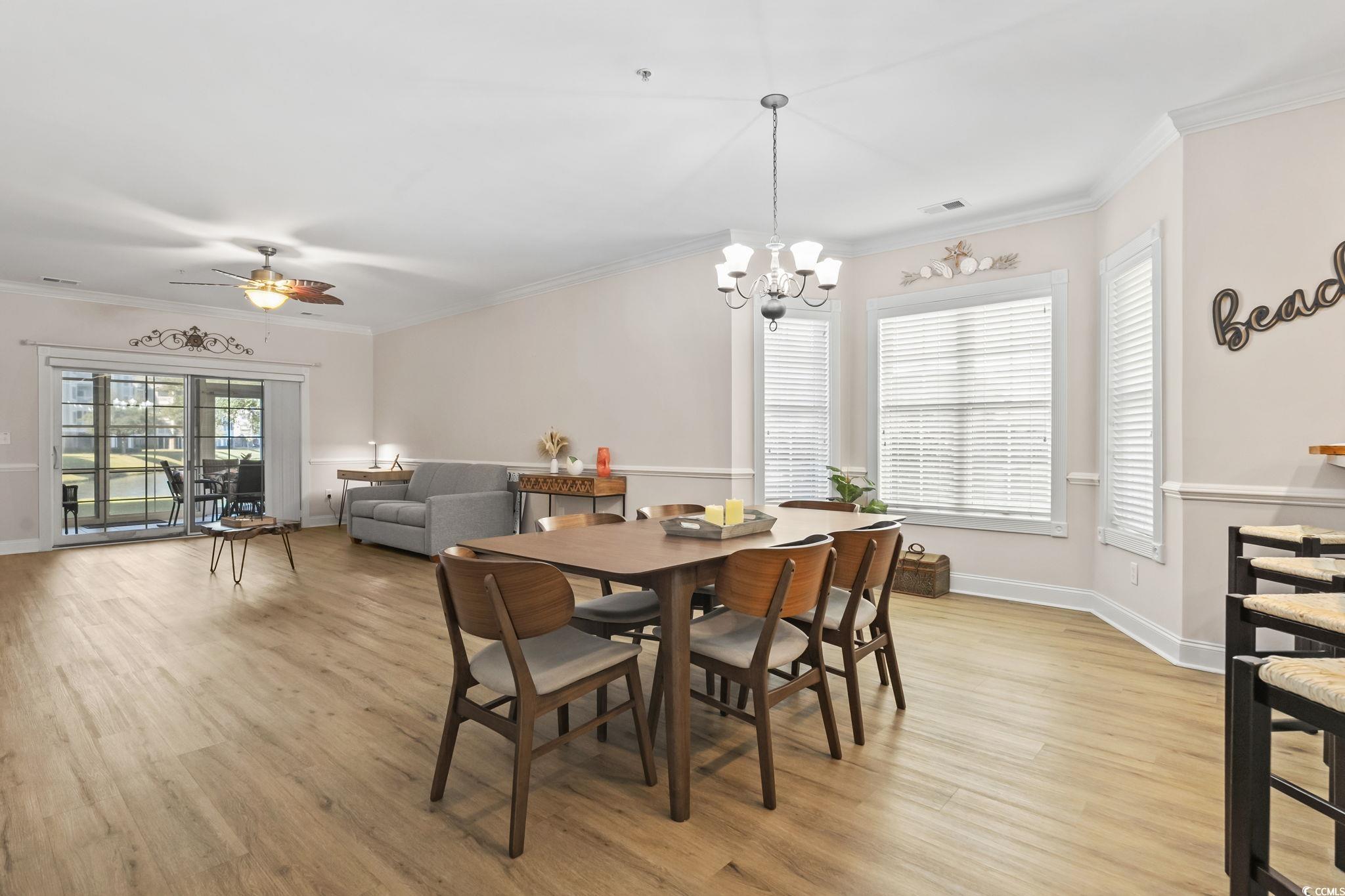 4821 Luster Leaf Circle, Unit 105 Myrtle Beach, SC 29577 - Photo 2 of 40 Dining room featuring ornamental molding, healthy amount of natural light, light wood-type flooring, and ceiling fan