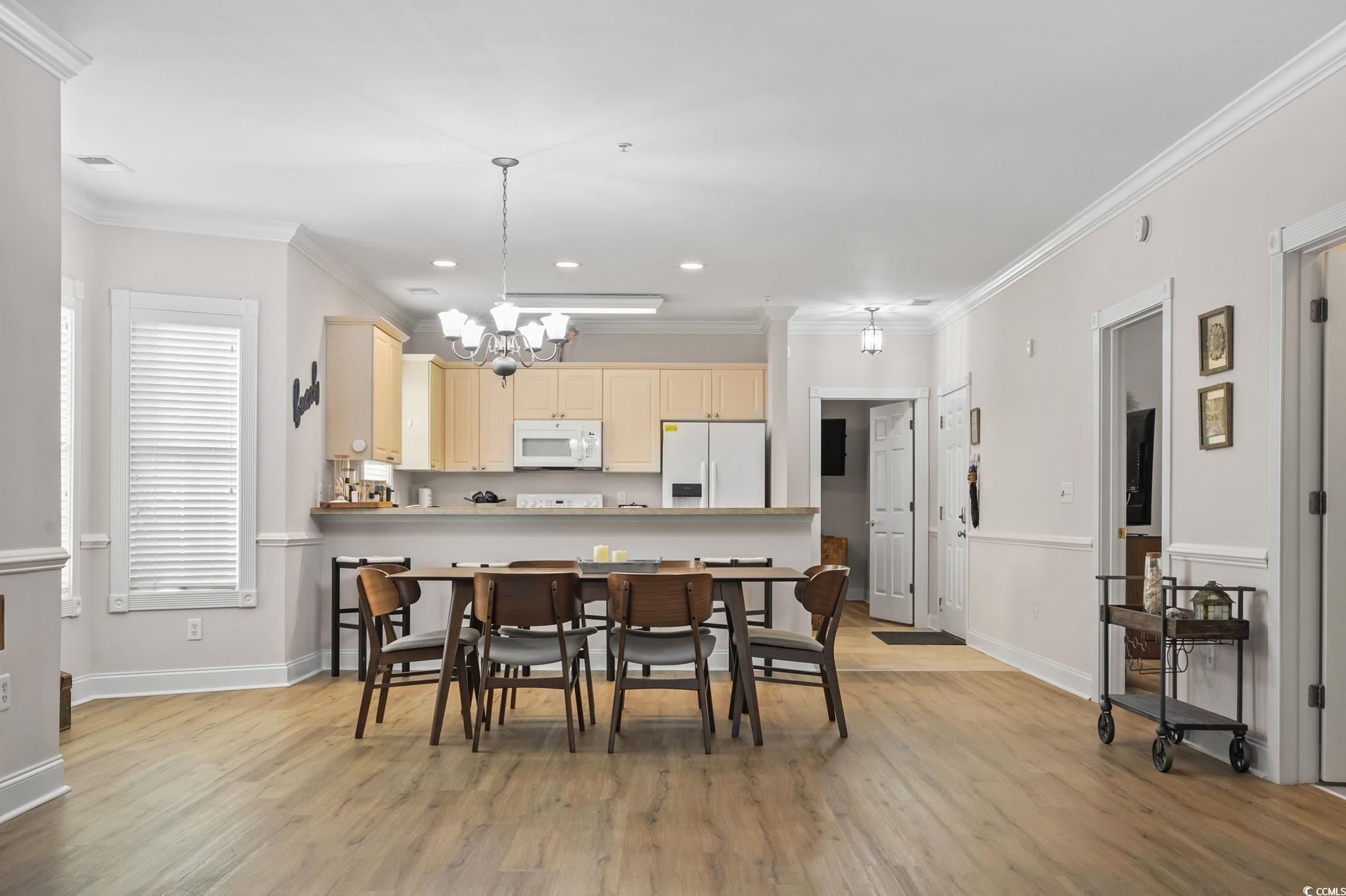 4821 Luster Leaf Circle, Unit 105 Myrtle Beach, SC 29577 - Photo 21 of 40 Dining room featuring crown molding, light wood-type flooring, recessed lighting, and a chandelier