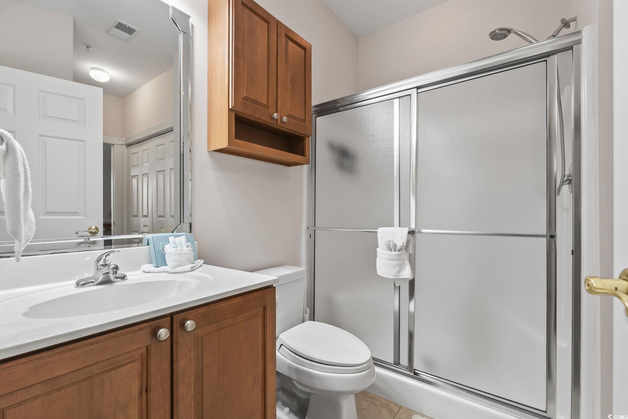 4821 Luster Leaf Circle, Unit 105 Myrtle Beach, SC 29577 - Photo 25 of 40 Bathroom with vanity, a stall shower, and light tile patterned floors