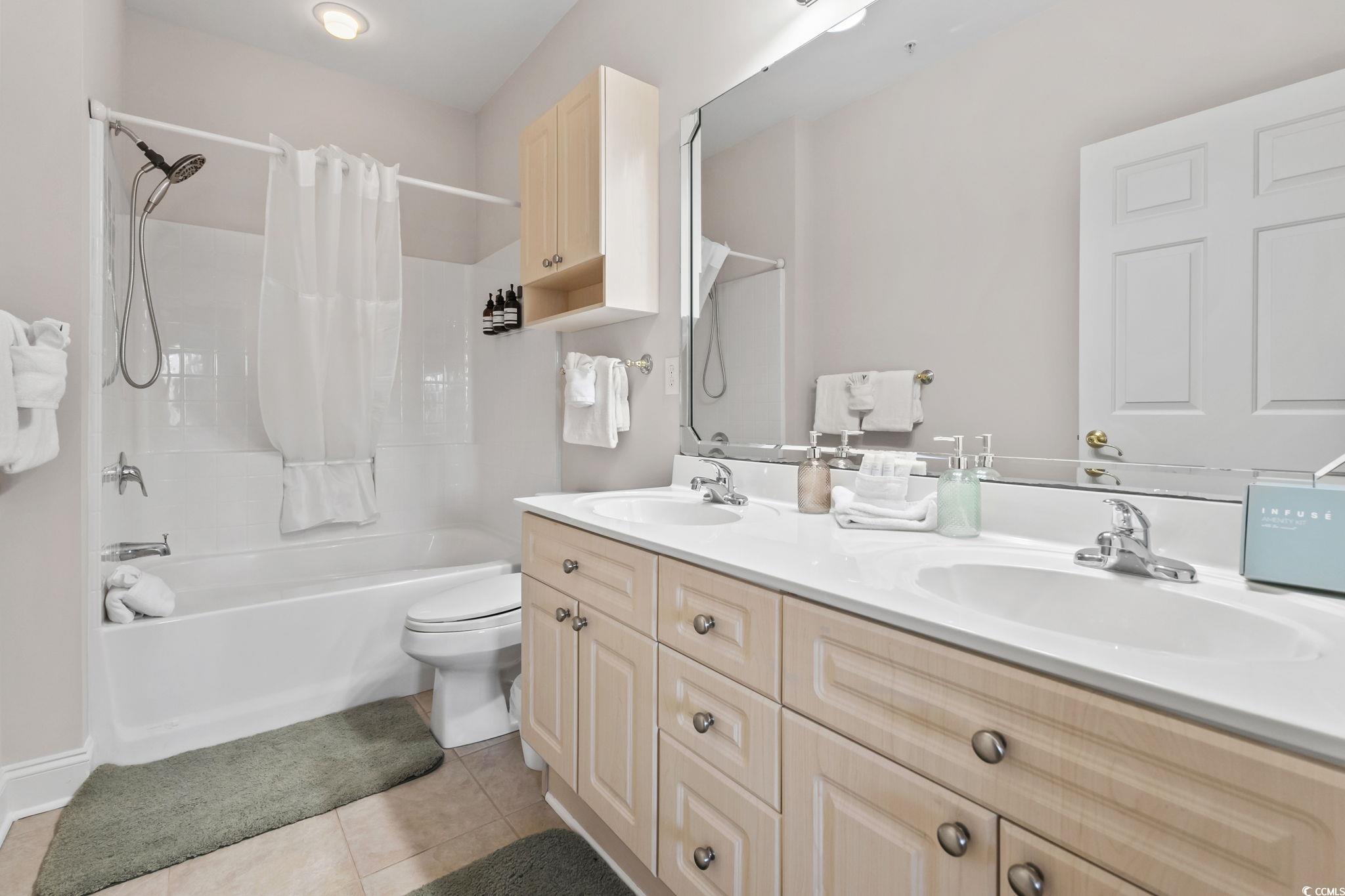 4821 Luster Leaf Circle, Unit 105 Myrtle Beach, SC 29577 - Photo 34 of 40 Bathroom featuring double vanity, shower / tub combo, and light tile patterned flooring