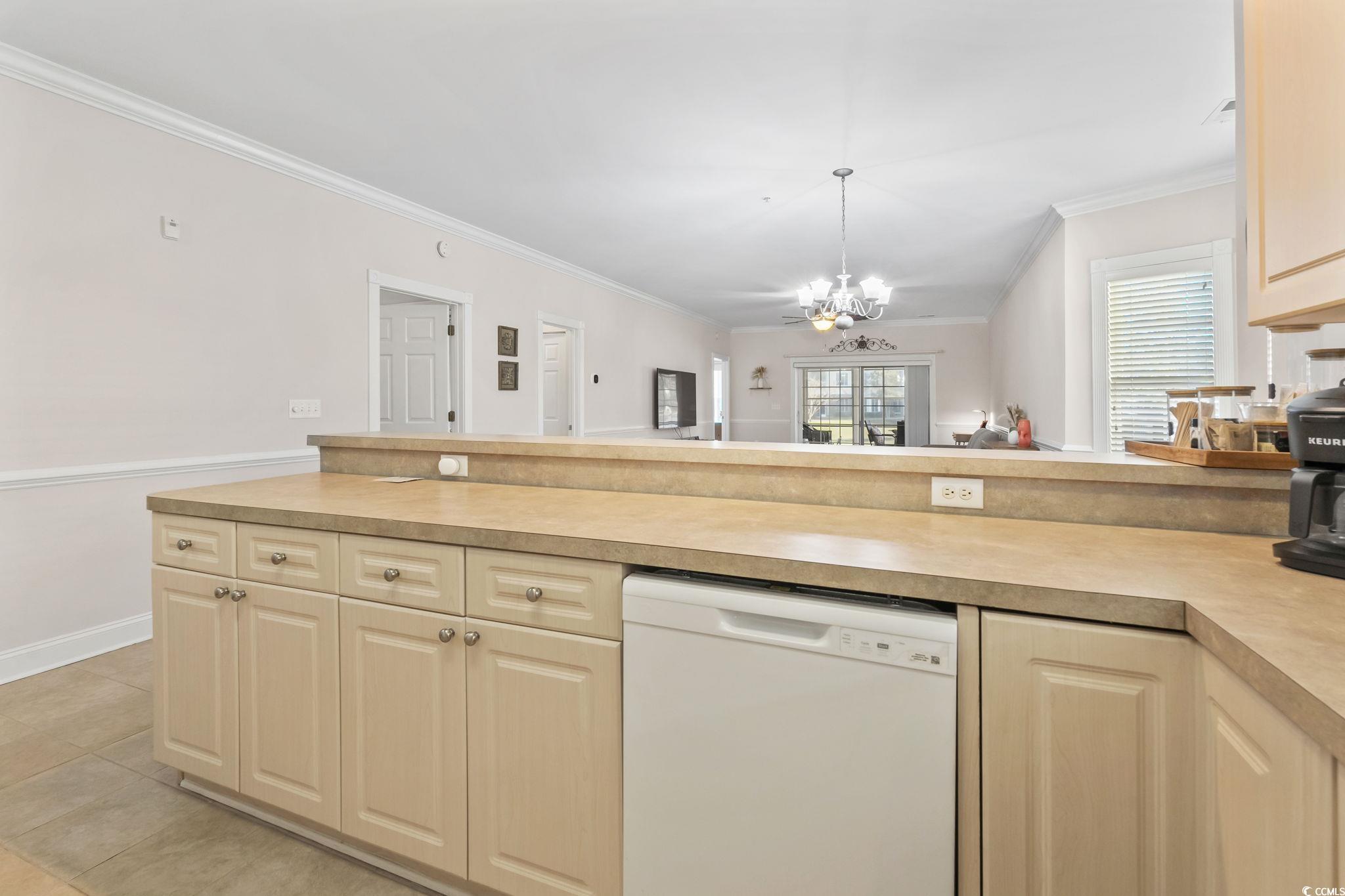 4821 Luster Leaf Circle, Unit 105 Myrtle Beach, SC 29577 - Photo 40 of 40 Kitchen featuring open floor plan, white dishwasher, light countertops, crown molding, and light tile patterned floors