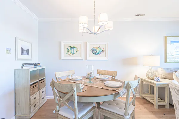 a view of a dining room with furniture a chandelier and wooden floor