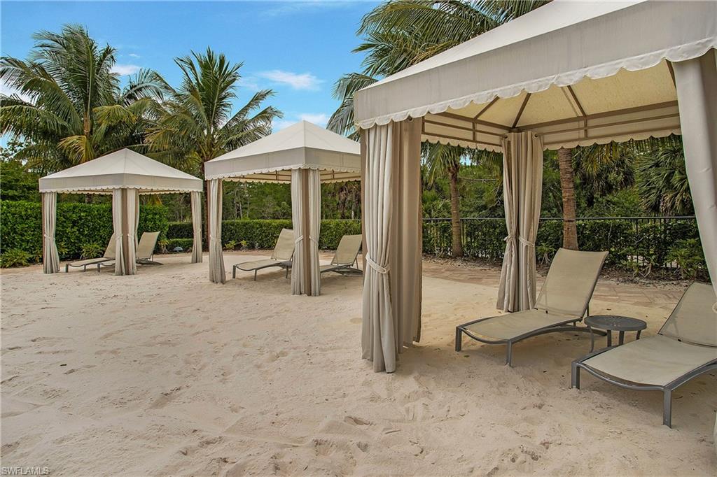 7674 Jacaranda Lane Naples, FL 34114 - Photo 38 of 45 a view of a patio with table and chairs under an umbrella