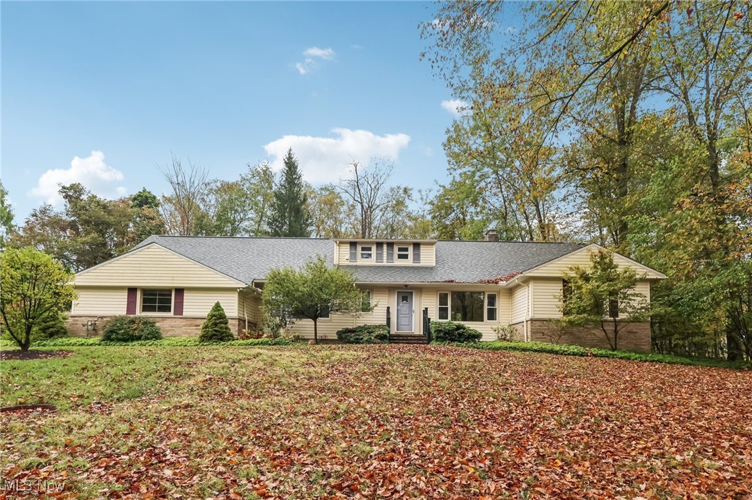 View of front of home featuring a chimney and a shingled roof