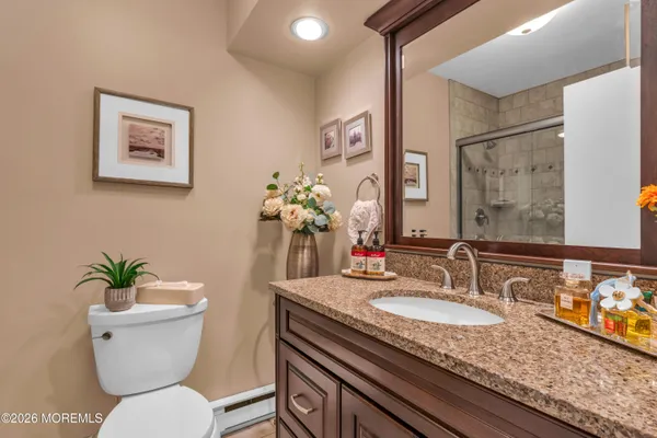 a bathroom with a granite countertop toilet sink and mirror