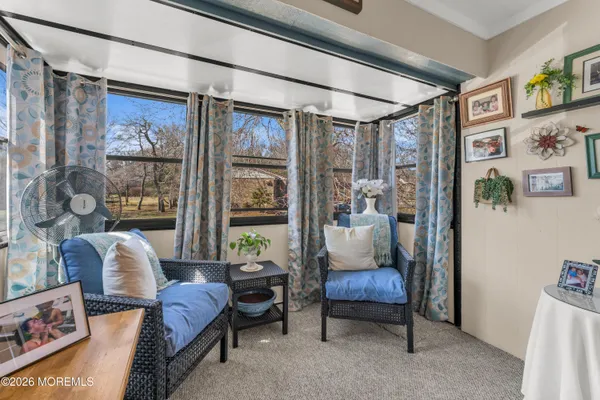 a living room with furniture a flat screen tv and a large window