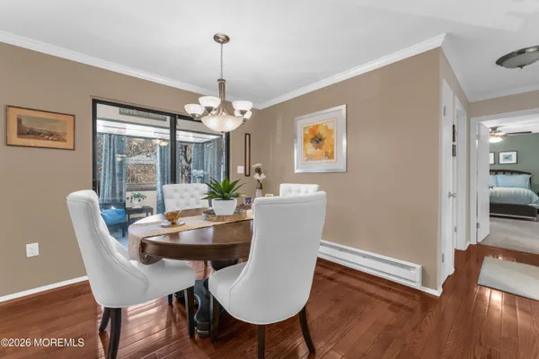 a dining room with furniture a chandelier and wooden floor