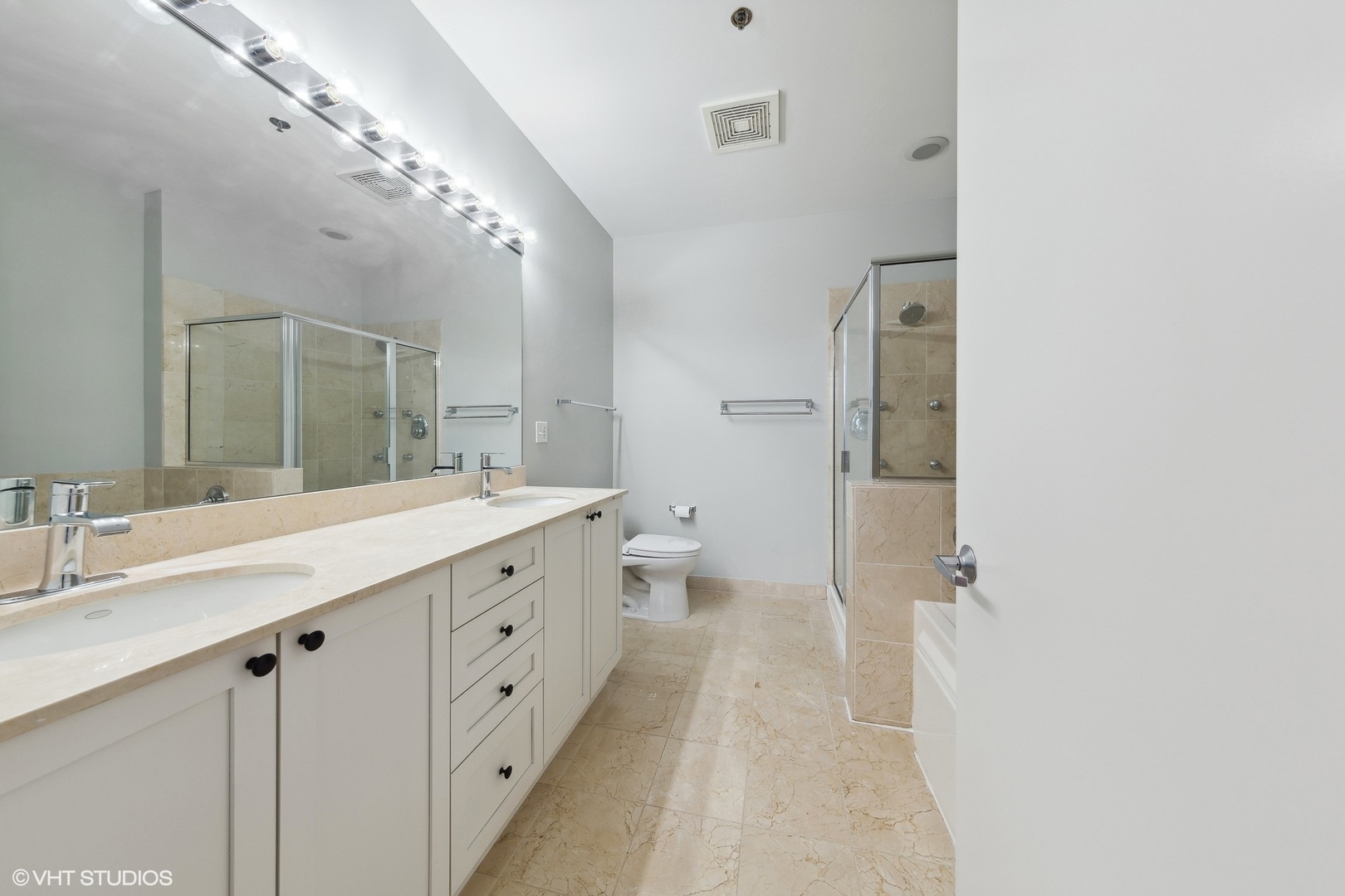 950 West Monroe Street, Unit 910 Chicago, IL 60607 - Photo 16 of 31 a spacious bathroom with a double vanity sink a large mirror and a shower