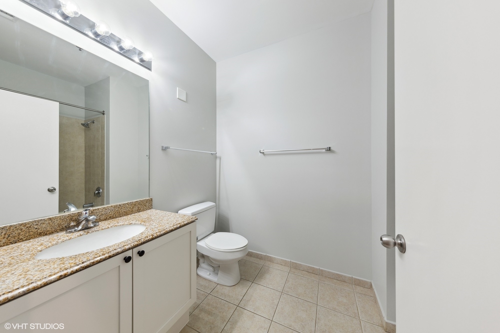 950 West Monroe Street, Unit 910 Chicago, IL 60607 - Photo 20 of 31 a bathroom with a granite countertop sink a toilet and a mirror