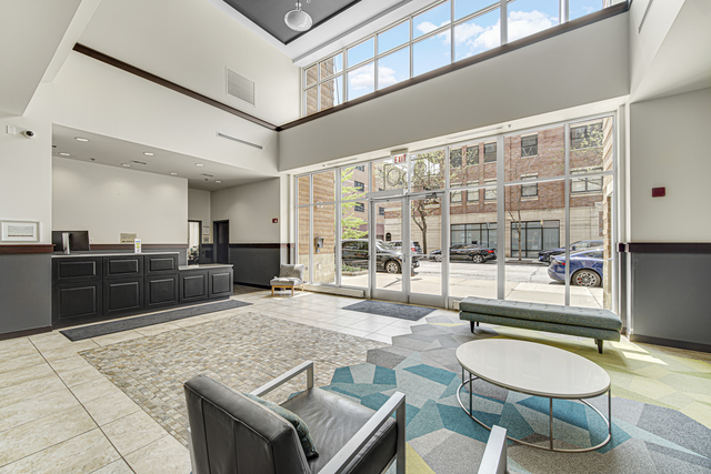 950 West Monroe Street, Unit 910 Chicago, IL 60607 - Photo 25 of 31 a living room with couches a table and chairs with wooden floor