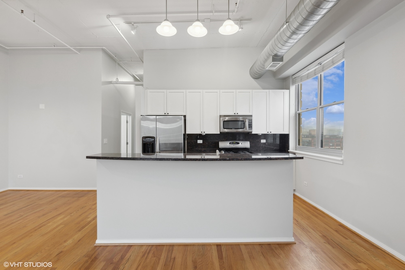 950 West Monroe Street, Unit 910 Chicago, IL 60607 - Photo 6 of 31 a kitchen with stainless steel appliances a microwave a stove a sink dishwasher and a microwave with wooden floor