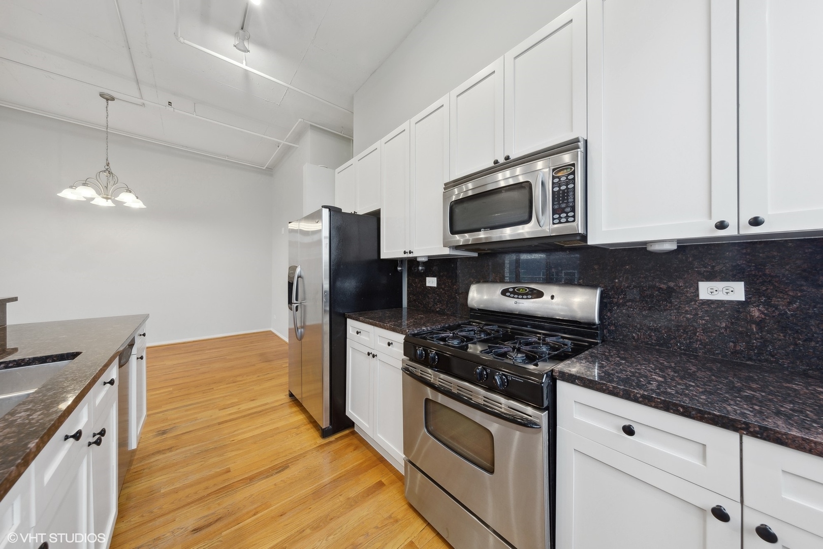950 West Monroe Street, Unit 910 Chicago, IL 60607 - Photo 8 of 31 a kitchen with granite countertop stainless steel appliances a stove microwave and cabinets