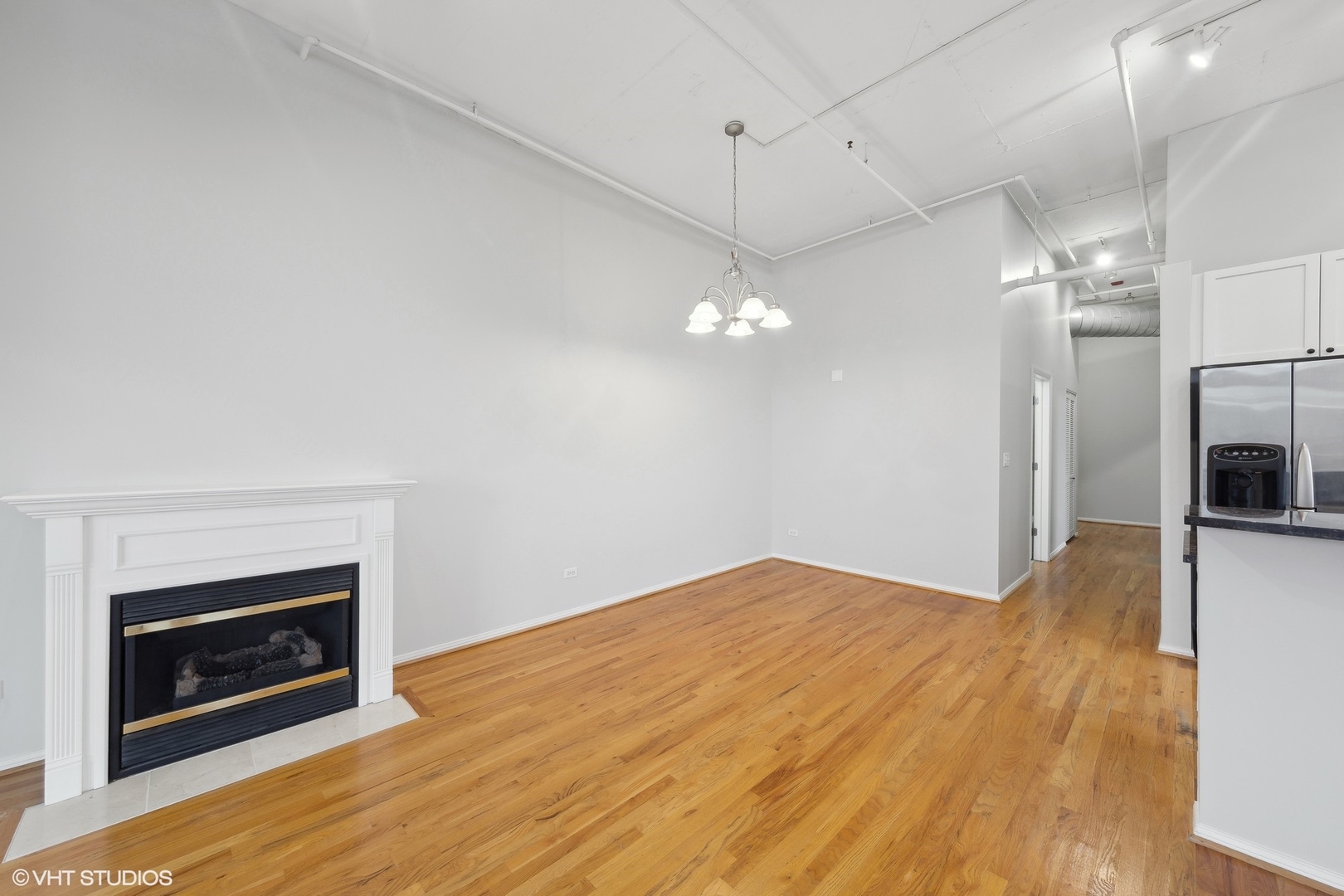 950 West Monroe Street, Unit 910 Chicago, IL 60607 - Photo 9 of 31 a view of empty room with wooden floor and fireplace