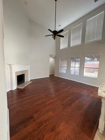 a view of empty room with fireplace and wooden floor