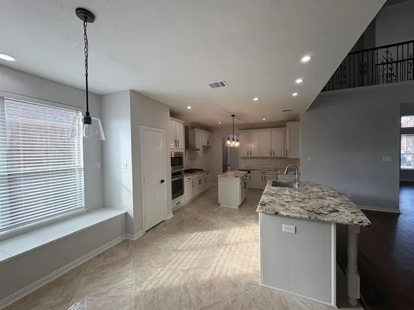 a kitchen with stainless steel appliances kitchen island granite countertop a sink and a refrigerator