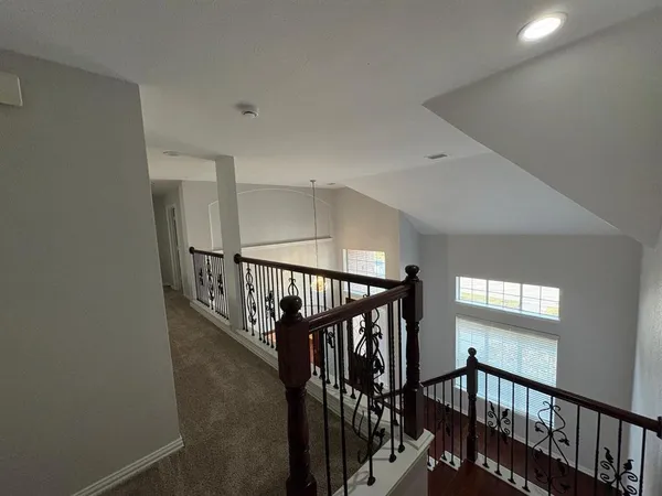 a view of staircase with railing and white walls