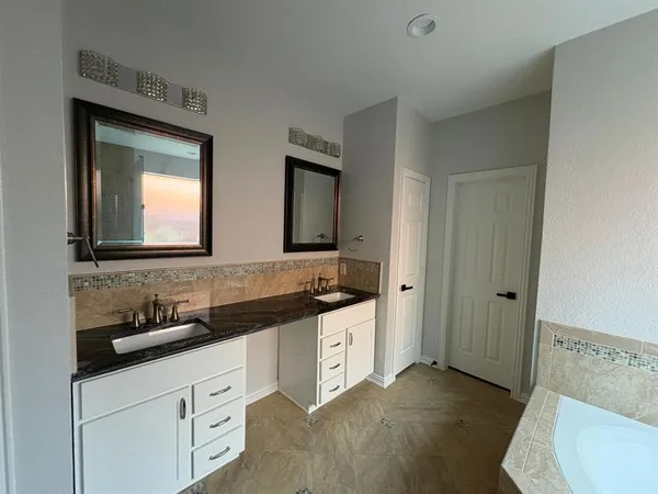 a bathroom with double sink and two mirror
