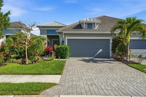 a front view of a house with a yard and potted plants
