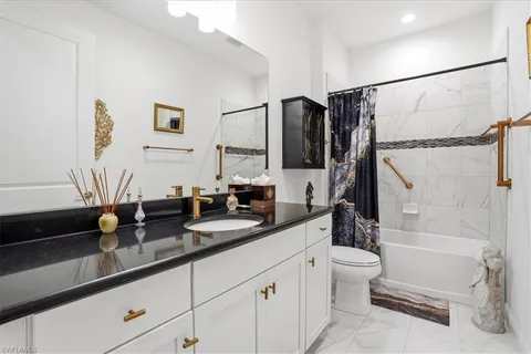 a spacious bathroom with a granite countertop sink a mirror a bathtub and a shower