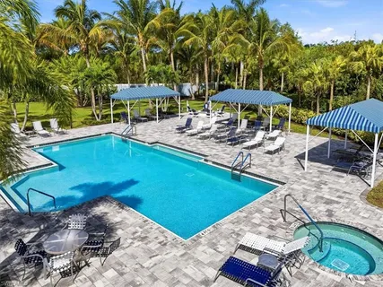 a view of a swimming pool with a table and chairs under an umbrella