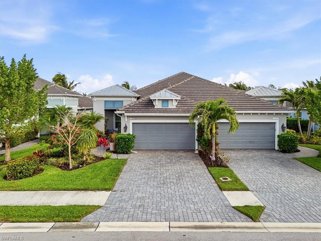 2318 Marquesa Circle Naples, FL 34112 - Photo 27 of 28 a front view of a house with a garden and plants