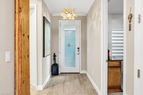 a view of a hallway with wooden floor and a bathroom
