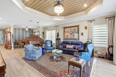 a living room with furniture a chandelier and a window