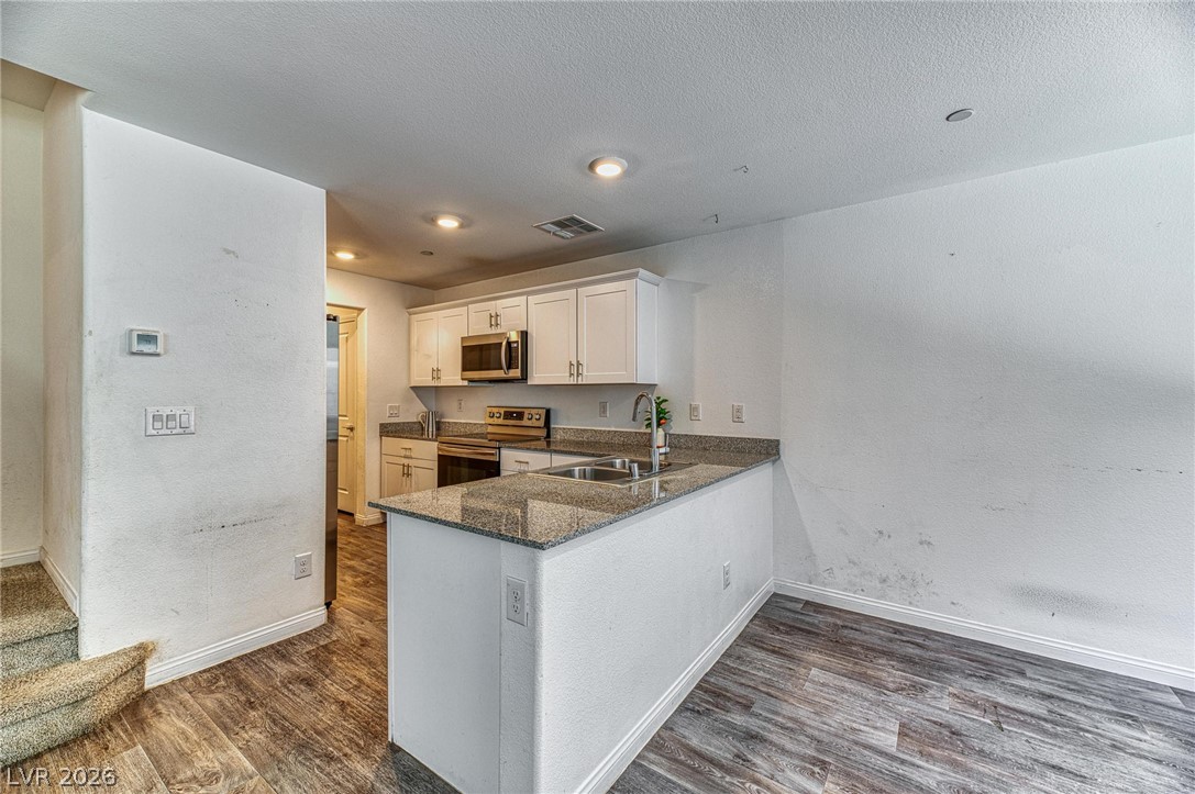 12105 Scarlet Ember Road, Unit 2 Las Vegas, NV 89183 - Photo 8 of 24 Granite counters and stainless steel appliances elevate this compact kitchen's appeal.