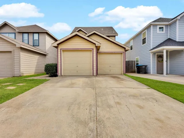 a view of garage yard and front view of a house