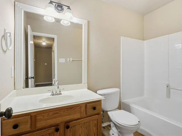 a bathroom with a sink toilet vanity and tub