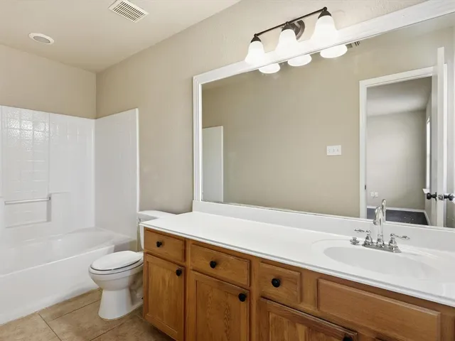 a bathroom with a granite countertop sink toilet a large mirror a bathtub and shower