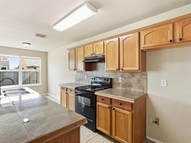 a kitchen with stainless steel appliances granite countertop a stove a sink and a microwave