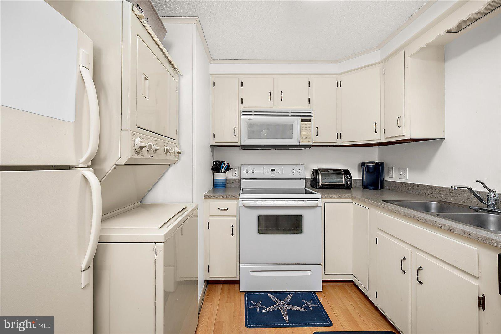 9 41st Street, Unit 320 Ocean City, MD 21842 - Photo 16 of 36 a kitchen with stainless steel appliances a stove a white refrigerator and white cabinets