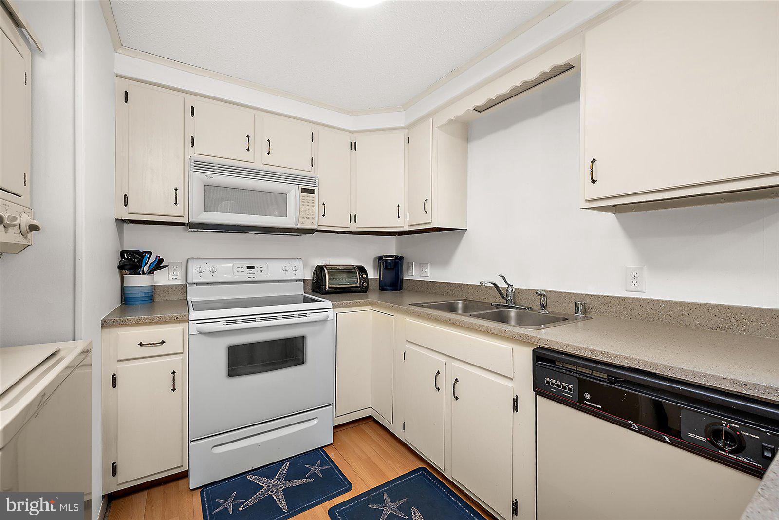 9 41st Street, Unit 320 Ocean City, MD 21842 - Photo 17 of 36 a kitchen with granite countertop white cabinets and white appliances