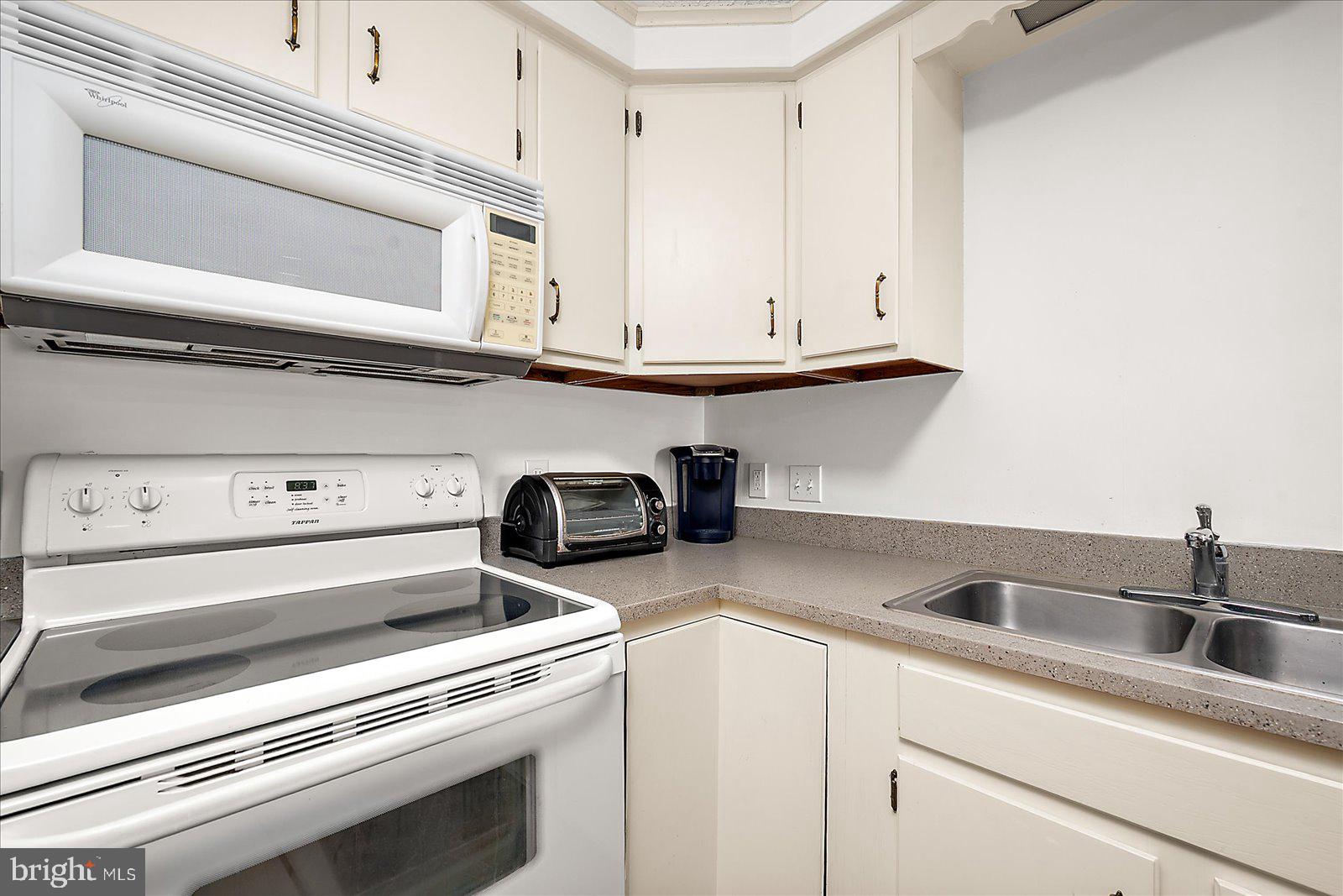 9 41st Street, Unit 320 Ocean City, MD 21842 - Photo 18 of 36 a kitchen with a stove and a microwave