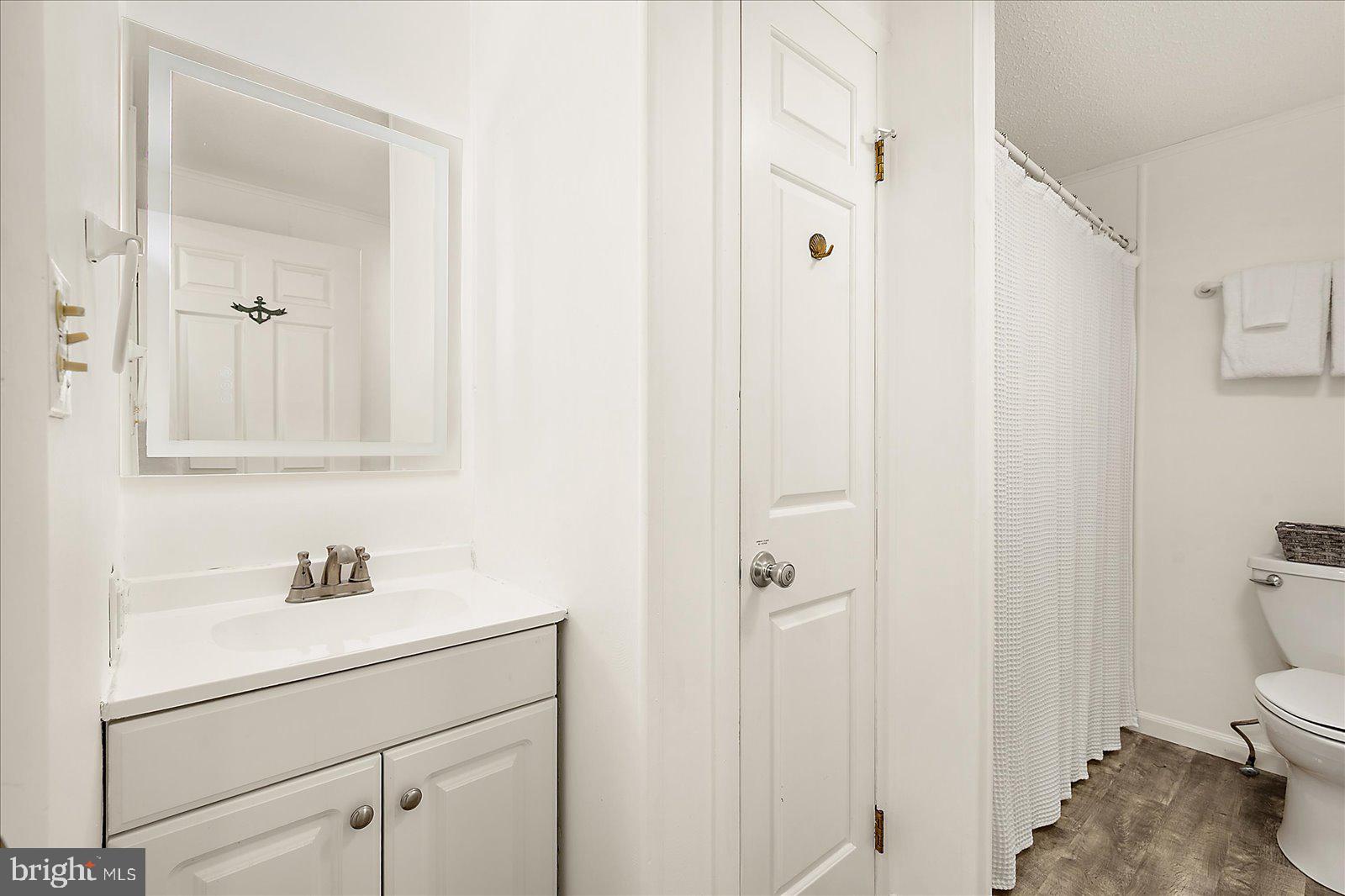 9 41st Street, Unit 320 Ocean City, MD 21842 - Photo 26 of 36 a bathroom with a sink a toilet and a mirror
