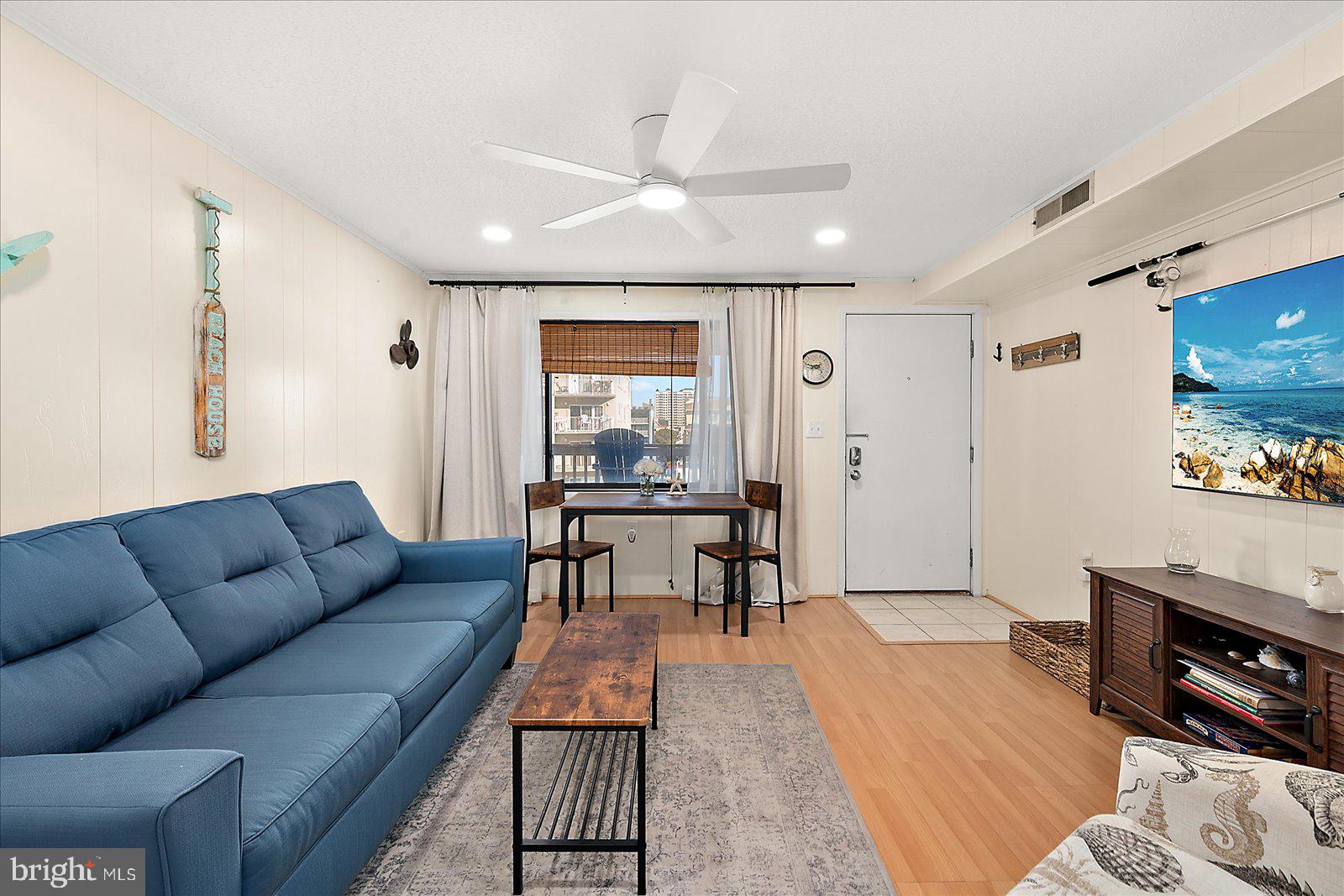 9 41st Street, Unit 320 Ocean City, MD 21842 - Photo 5 of 36 a living room with furniture a flat screen tv and a dining table