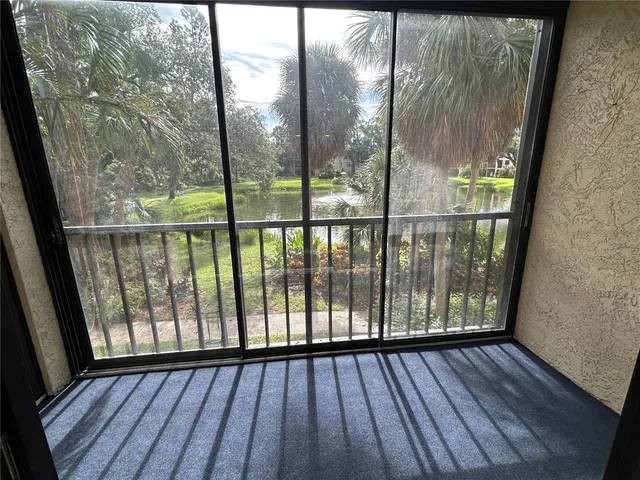a living room with patio furniture and a floor to ceiling window