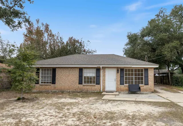 a front view of a house with a garden and yard
