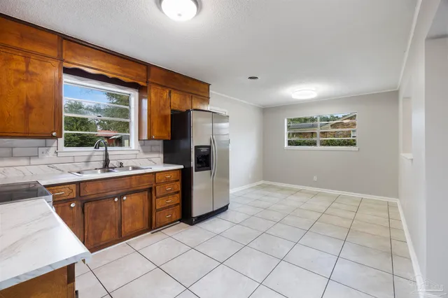 a open kitchen with stainless steel appliances granite countertop a refrigerator and a sink
