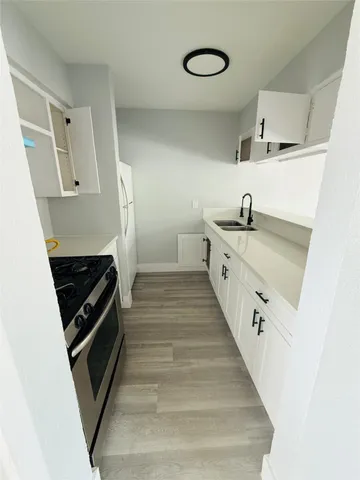 a kitchen with white cabinets and appliances