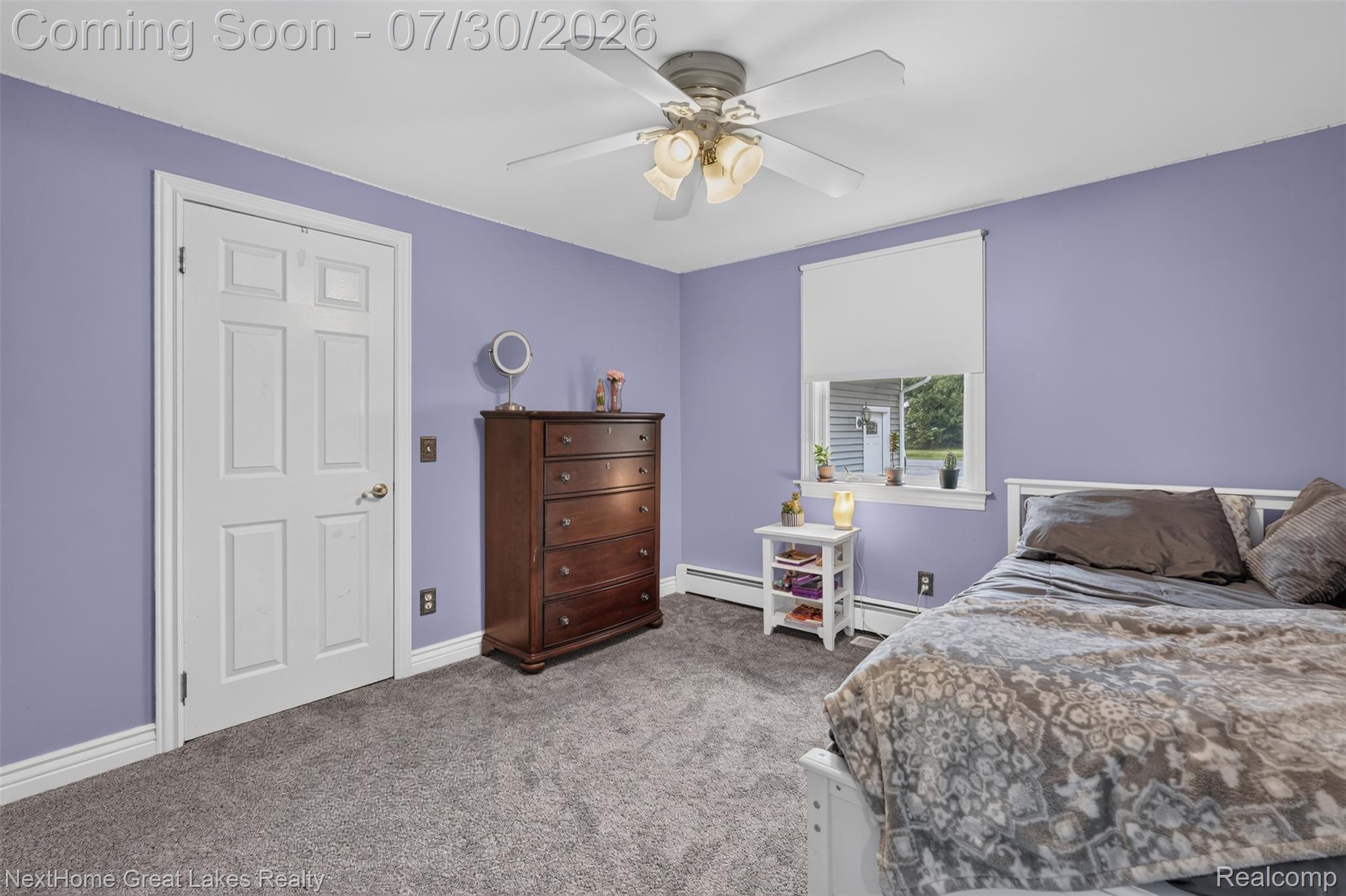 6249 North New Lothrop Road New Lothrop, MI 48460 - Photo 30 of 50 Carpeted room featuring a ceiling fan, a window with roller shade, and a white door with panel detailing