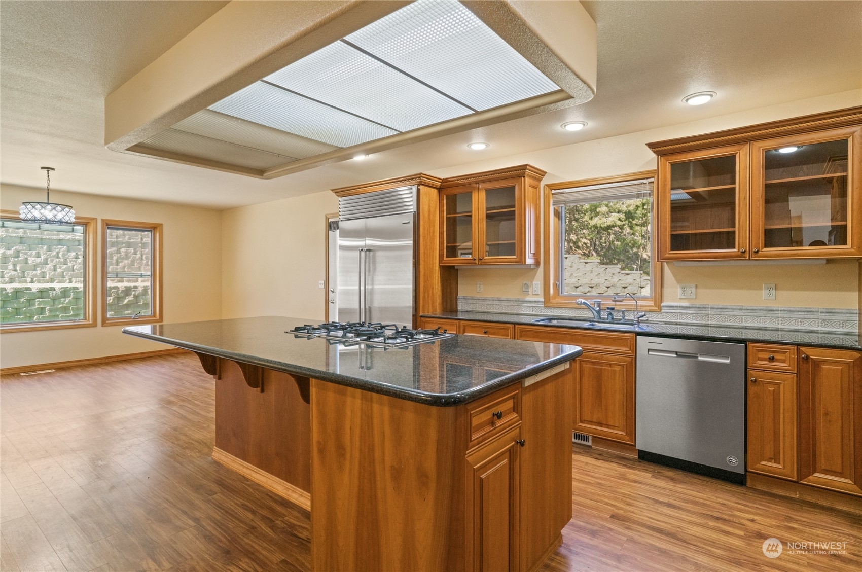 8 Valley View Park Road Omak, WA 98841 - Photo 17 of 40 a kitchen with stainless steel appliances granite countertop a sink and wooden cabinets with wooden floors